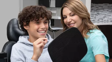 tc and teenage boy smiling at mirror with Spark aligner